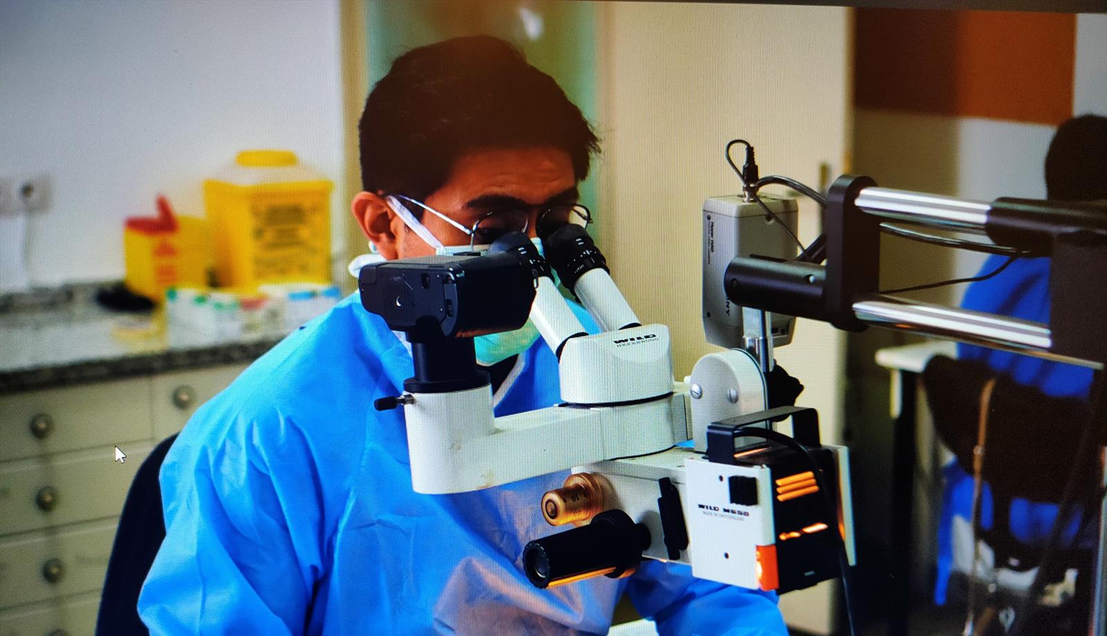 Dr. Paul Luna Ávila durante una actividad práctica de formación con microscopio
